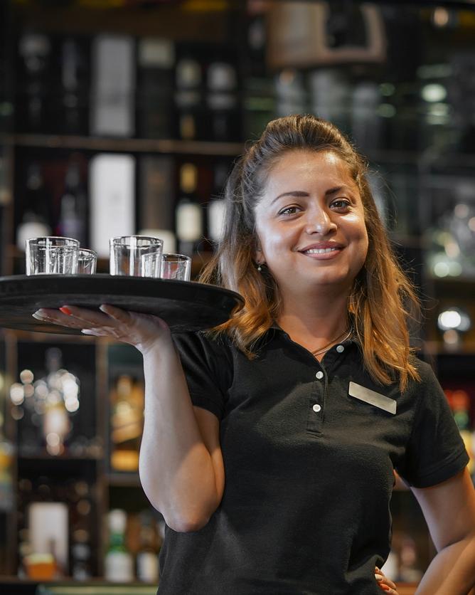 Servicekraft mit Tablett an der Bar